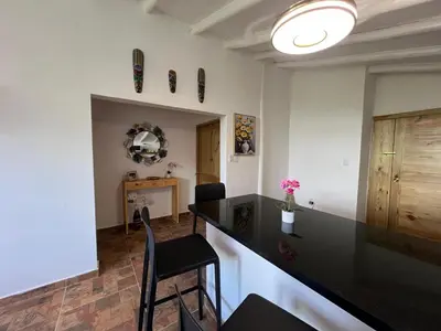 a kitchen with a black counter and a table and chairs at Bright studio in the heart of Las Galeras in Las Galeras