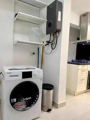 a kitchen with a dishwasher and a tv on a wall at Modern apartment in Gurabo Santiago in Santiago de los Caballeros