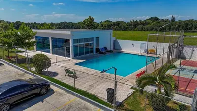 a car parked in front of a house with a swimming pool at Modern apartment in Gurabo Santiago in Santiago de los Caballeros