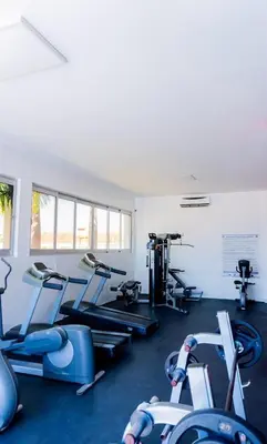 a gym with several treadmills and cardio machines at Modern apartment in Gurabo Santiago in Santiago de los Caballeros