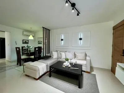 a living room with a white couch and a table at Modern apartment in Gurabo Santiago in Santiago de los Caballeros