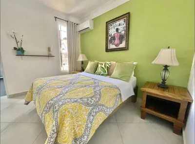 a bedroom with a bed and a table with a lamp at 10 bedroom huge villa close to Sosua downtown in Sosúa