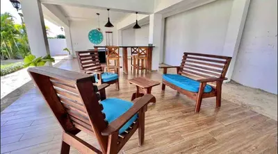 a group of wooden chairs sitting on a porch at 10 bedroom huge villa close to Sosua downtown in Sosúa