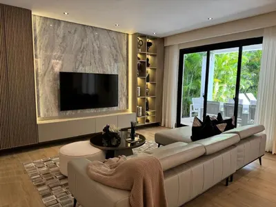 a living room with a large white couch and a tv at Luxury Villa in Punta Cana in Punta Cana