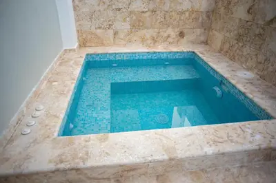 a large swimming pool in a bathroom with blue tiles at Presmita rose 24 in Punta Cana