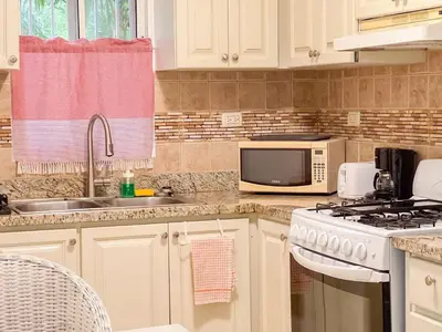 a kitchen with a sink and a stove and a microwave at Garden Condos APT 44 - Comfy 1BR APT in Sosua in Sosúa