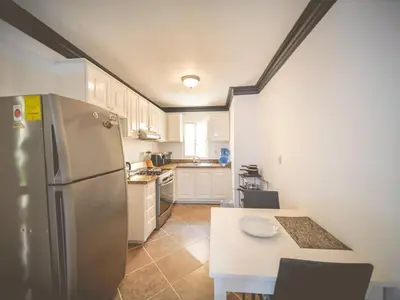 a kitchen with a stainless steel refrigerator and a table at Garden Condos 7 - Central Apartment in Strip in Sosúa