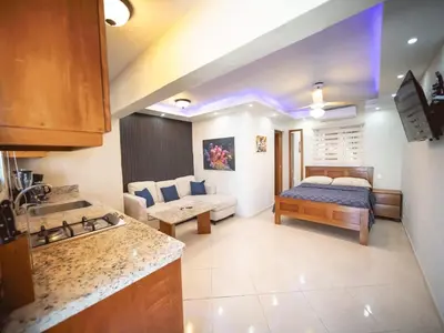 a kitchen and a living room with a bed in a room at Casa de Compai Studio 2 Walk to Beach & Fun in Sosúa