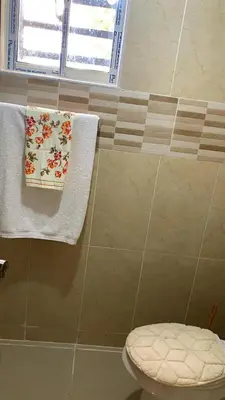 a bathroom with towels and a toilet and a window at Comfortable Apartament 20 Minutes from the airport in San Isidro