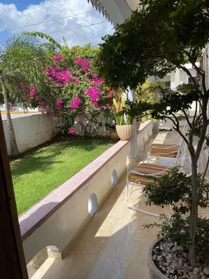 a row of chairs on a balcony with pink flowers at Exclusive Beachside House with Private Backyard in Río San Juan