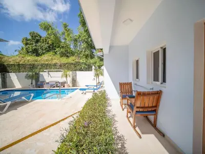 a patio with two chairs next to a swimming pool at Casa de Compai Unit 4 Comfort in Central Sosua in Sosúa