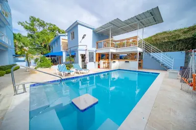 a swimming pool with blue water in front of a house at Stylish 1BR in Sosua Walkable & Pool Fast WIFi in Sosúa