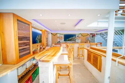 a kitchen with a bar with wooden tables and chairs at Stylish 1BR in Sosua Walkable & Pool Fast WIFi in Sosúa