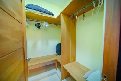 a small room with a closet with a wooden door at Stylish 1BR in Sosua Walkable & Pool Fast WIFi in Sosúa