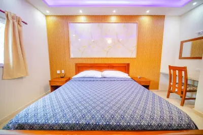 a bedroom with a bed and a painting on the wall at Stylish 1BR in Sosua Walkable & Pool Fast WIFi in Sosúa