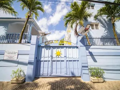 a blue and white house with a gate and palm trees at CC 8 Casa de Compai Unit 8 AC WiFi & Full Kitchen in Sosúa