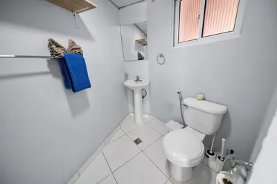 a white bathroom with a toilet and a sink at Centric Studio in Sosua Center Pool & Workspace in Sosúa