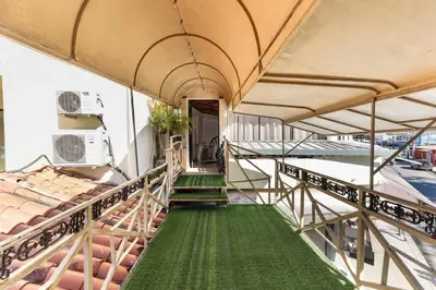 a balcony with two beds and a green carpet at Centric Studio in Sosua Center Pool & Workspace in Sosúa