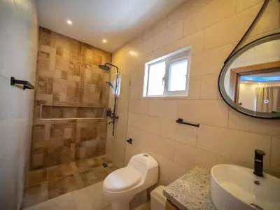 a bathroom with a toilet and a sink and a mirror at Green Palace 7 Bedroom Villa in Sosua with Security in Sosúa