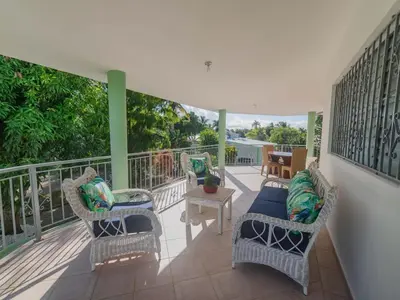 a porch with wicker chairs and a table at 14 Bedroom Villa 2 mins from Sosua in Sosúa