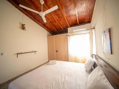 a bedroom with a large bed with a wooden ceiling at Colonial 2BR Apartment 2 mins walk to beach in Sosúa