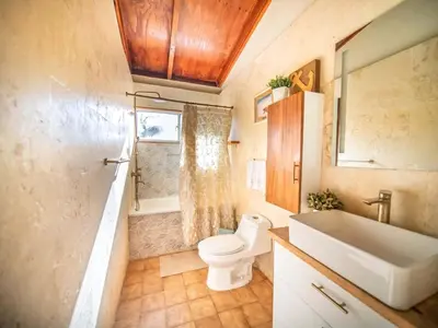 a bathroom with a toilet and a tub and a sink at Colonial 2BR Apartment 2 mins walk to beach in Sosúa