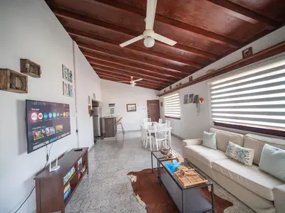 a living room with a couch and a flat screen tv at HUGE Balcony APT next to HARD ROCK CAFE and Beach in Sosúa