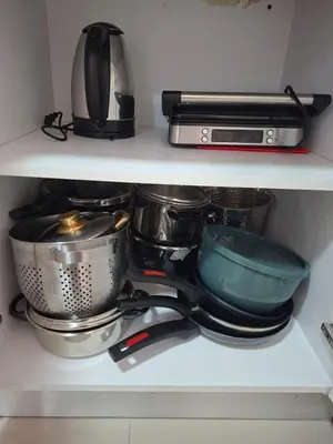 a shelf filled with pots and pans and a microwave at Apartment in Santo Domingo in El Caliche