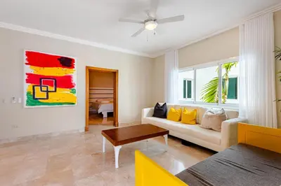 a living room with a couch and a table at Large apartment at the foot of the beach in Punta Cana