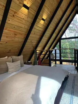 a bed in a room with a wooden ceiling at Alpina Village, Jarabacoa in Jarabacoa