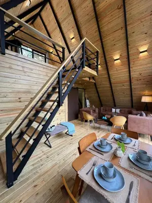 a staircase in a room with tables and chairs at Alpina Village, Jarabacoa in Jarabacoa