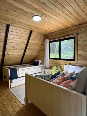 a room with two beds in a log cabin at Alpina Village, Jarabacoa in Jarabacoa
