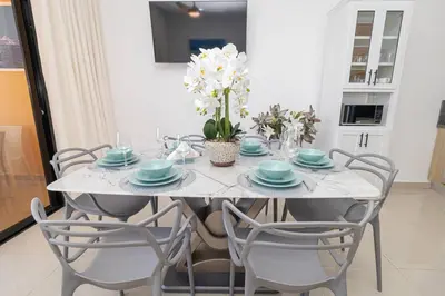 a dining room table with blue and white plates and chairs at Stylish 2BR Apartment in the Heart of Bayahibe in San Rafael del Yuma