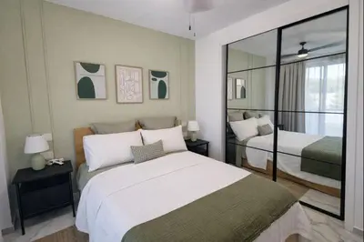 a bedroom with two beds and a mirror at Aqua Poolside Serenity Pool & Golf 2B Cana Bay in Punta Cana