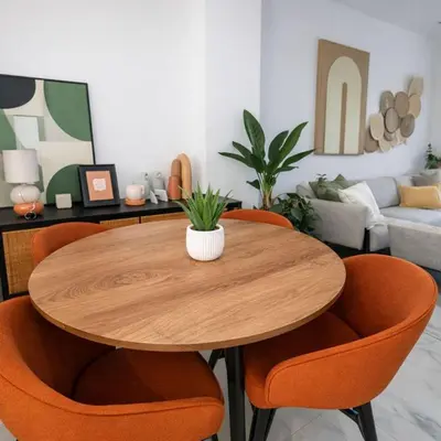 a wooden table with orange chairs in a living room at Aqua Poolside Serenity Pool & Golf 2B Cana Bay in Punta Cana