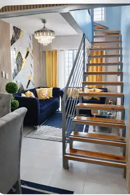 a spiral staircase in a living room with a couch at Spacious 3BR Duplex with Private Rooftop , Ideal for Monthly & Corporate Stays in San Isidro