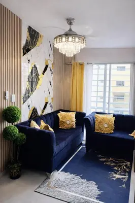 a living room with a blue couch and a chandelier at Spacious 3BR Duplex with Private Rooftop , Ideal for Monthly & Corporate Stays in San Isidro