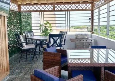 a screened in porch with a table and chairs at Spacious 3BR Duplex with Private Rooftop , Ideal for Monthly & Corporate Stays in San Isidro