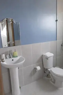 a bathroom with a sink and a toilet and a mirror at Spacious 3BR Duplex with Private Rooftop , Ideal for Monthly & Corporate Stays in San Isidro