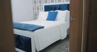 a bedroom with a white bed with blue pillows at Mediterraneo in Canabacoa