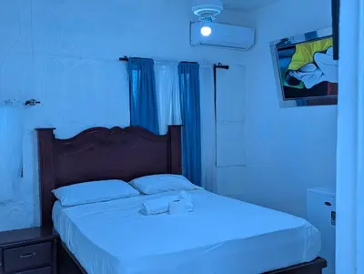 a bedroom with a bed with a blue light at Casa Gadlu Hotel in Santo Domingo