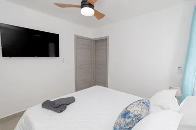 a bedroom with a bed with a ceiling fan and a television at Tropical Studio Getaway in Bayahibe in San Rafael del Yuma