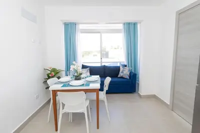 a living room with a table and a blue couch at Tropical Studio Getaway in Bayahibe in San Rafael del Yuma