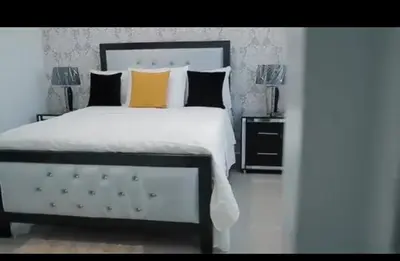 a bedroom with a large white bed with two lamps at Airbnba304 in Canabacoa