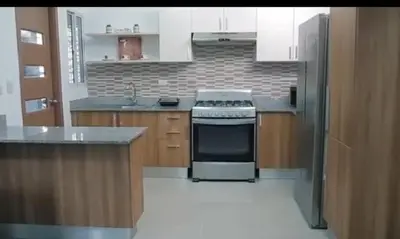 a kitchen with white cabinets and a stove top oven at Airbnba304 in Canabacoa