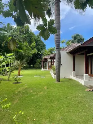 a house with a green yard with palm trees at Residence in Juan Dolió, Guavaberry, is ideal in Los Conucos