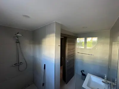 a bathroom with a sink and a shower and a mirror at Alexger Beachfront Apartament Bavaro, Punta Cana in Punta Cana