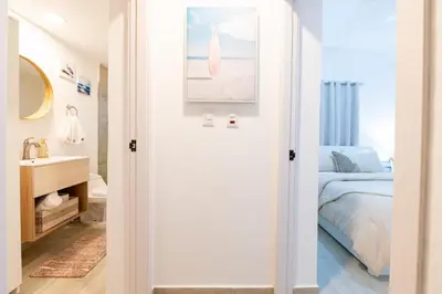 a bedroom with a bed and a bathroom with a sink at Punta Cana Penthouse Private Picuzzi & Beach Access in Punta Cana