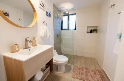 a bathroom with a sink and a toilet and a mirror at Punta Cana Penthouse Private Picuzzi & Beach Access in Punta Cana