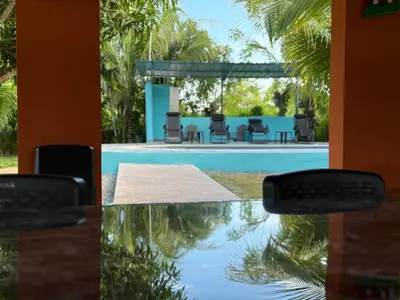a table and chairs in front of a pool at Rancho Doña Rita in Higuey